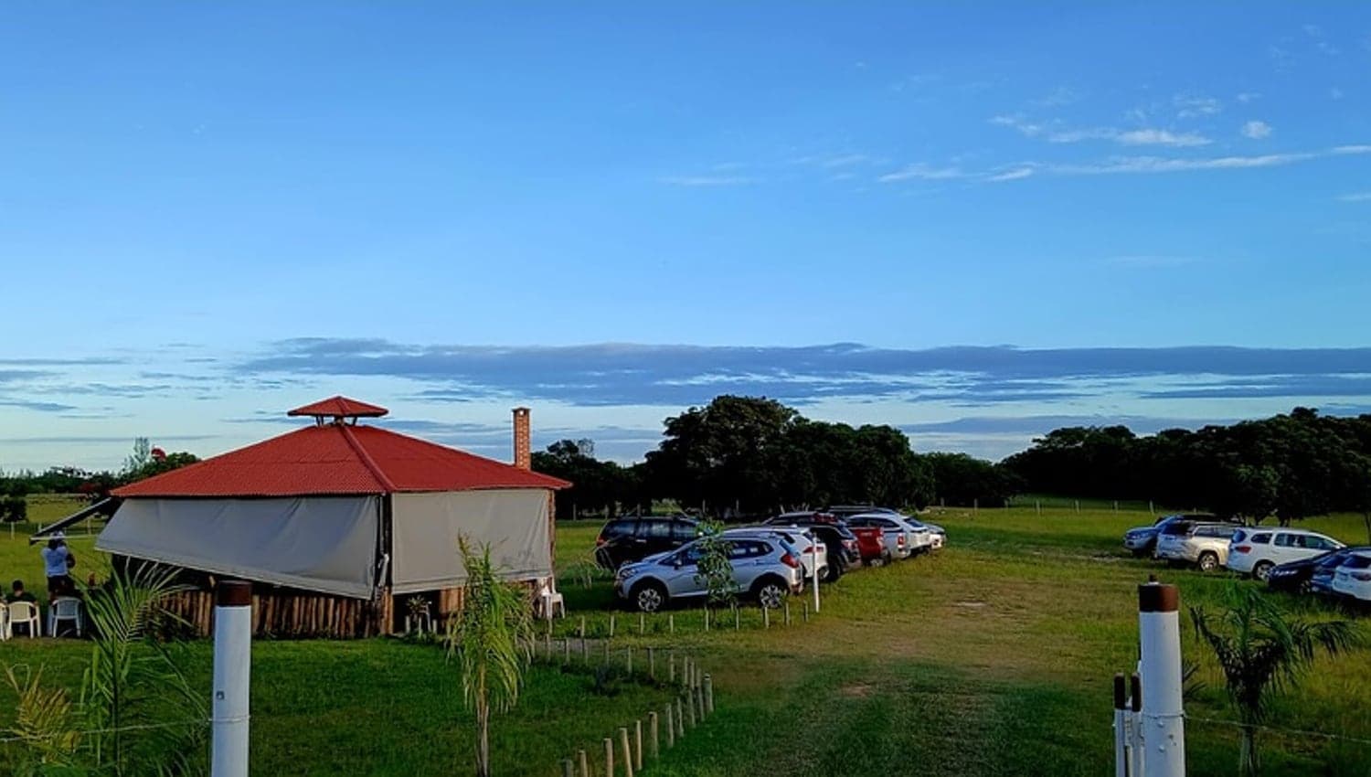 O Rancho Aroeira ao fim da tarde com os carros estacionados no gramado